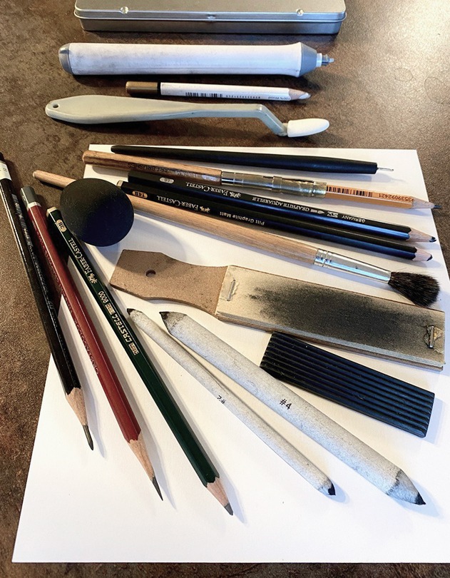 On the table are neatly arranged various materials for drawing pencil portraits: a range of pencils, erasers, sharpeners, blending stumps, and other art tools. These elements create a creative atmosphere, ready for the realization of unique works of art.