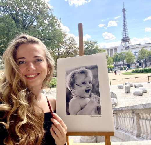 Artist Anneli with a pencil portrait in front of the Eiffel Tower
